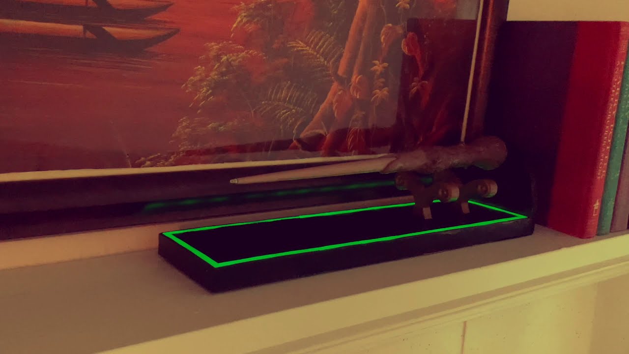A wand suspended above an illuminated display base