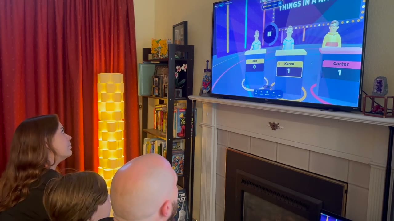 A family playing the AI trivia show on a television