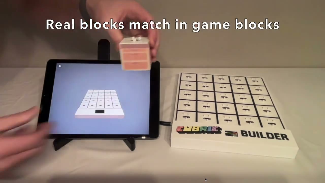 A smart physical block and a 5-by-5 board alongside the matching digital build on a tablet